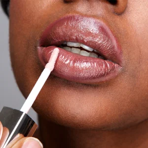 Aplicação de gloss nos lábios, representando a categoria de maquilhagem Prom Cosmetics
